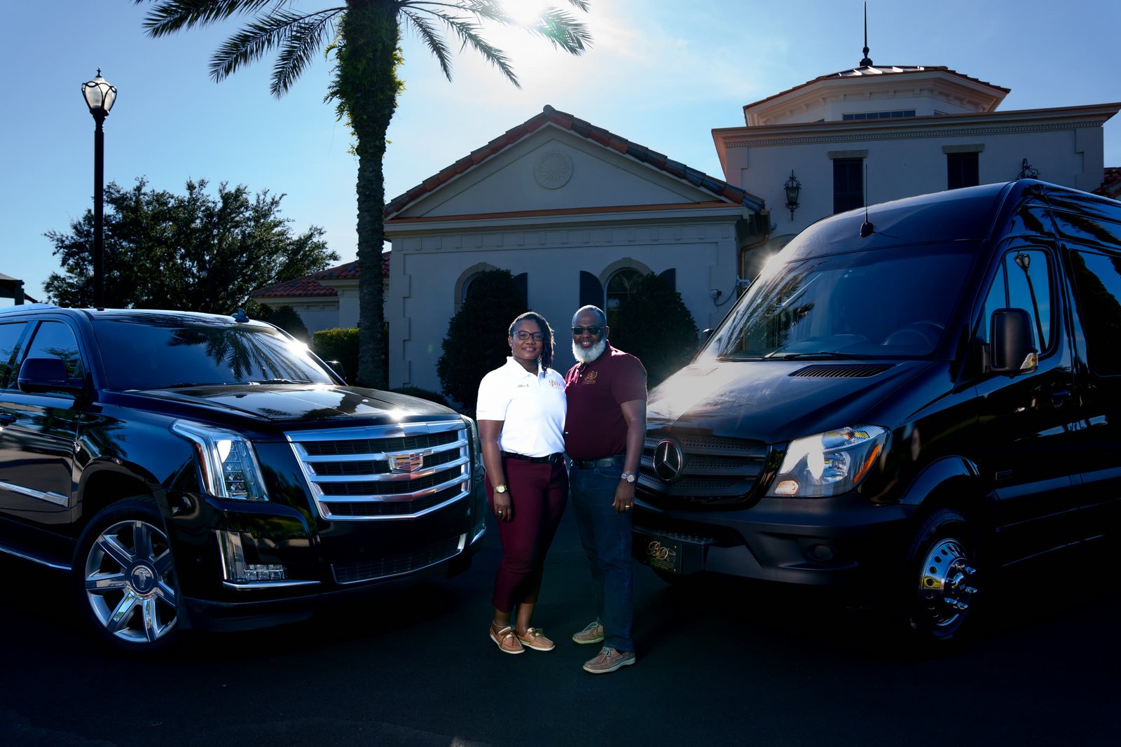 Danny and a passenger standing with the Escalade and Sprinter